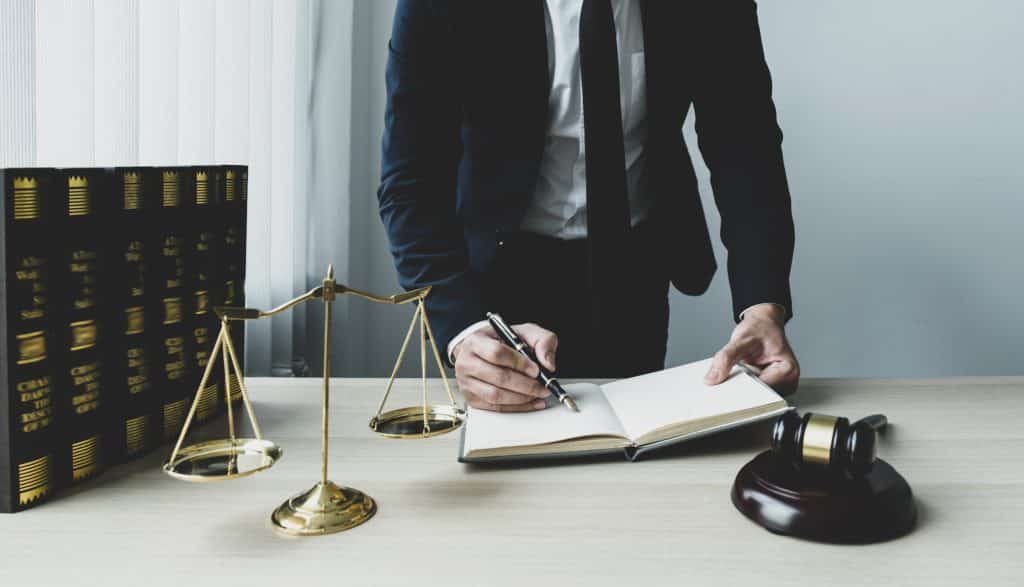 Lawyer hand holding pen and providing legal consult business dispute service at the office