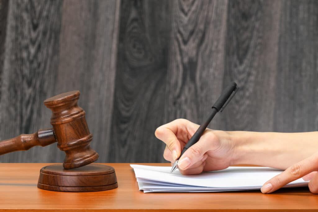 Judge Writing On Paper In Courtroom